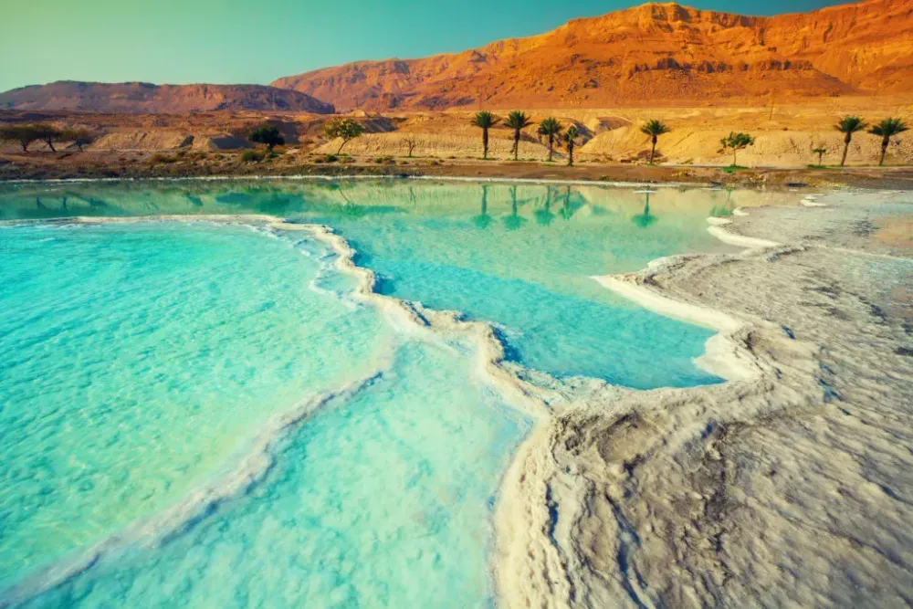 Salt shore along the dead sea with desert mountains in the background